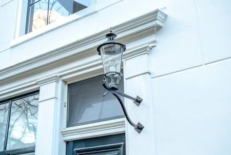 The street lamp was hanging on the white wall of the house. Building and architecture backgroundの写真素材