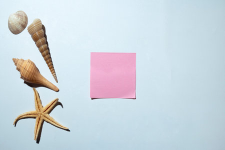 Starfish and seashells with a pink card on a white background. Copy space. Mockup. Valentine Card. Decoration for Valentine celebrationの写真素材
