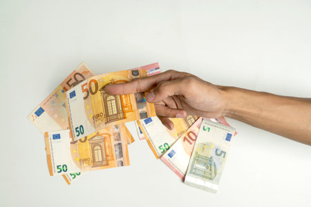 Human hand holding euro banknote cash on white background. Finance and European currency conceptの写真素材
