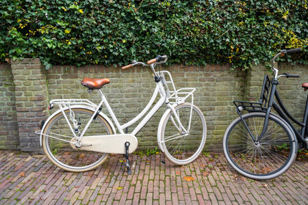 White and black bicycle leaned on brick wall beside the city street in Amersfoort, Netherlandsの写真素材