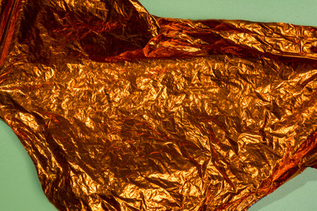 Top view of crumpled golden paper on a colored background. Abstract pattern texture background. Copy space or template. Flat layの写真素材