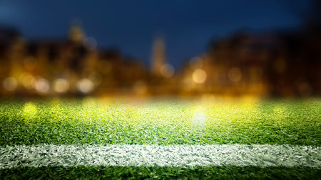 Empty sports court stadium with green grass and blurred spotlights. The field is ready for a game. Concept of Professional sport, Competition, Championship, and match. Soccer stadium field backgroundの写真素材