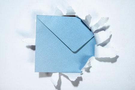 Envelope from the hole of ripped paper. Mockup or Copy space. Template. Greetings or invitation. Concept of message or communicationの写真素材
