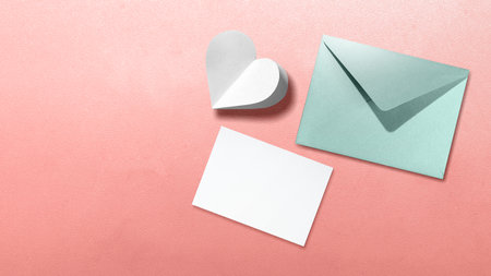 White heart with empty card and envelope on a colored background. Copy space. Mockup. Valentine...