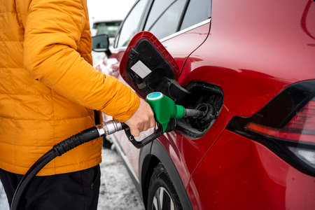 Man refueling car at a gas station in Iceland. Transportation, travel, industry, service, winter...