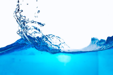 Closeup view of dynamic flowing blue water waves on white background. Liquid splash. Texture and abstract backgroundの写真素材