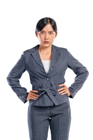 Portrait of an Asian businesswoman feeling angry with a hand on her waist isolated over a white background. Concept of business or work problemの写真素材