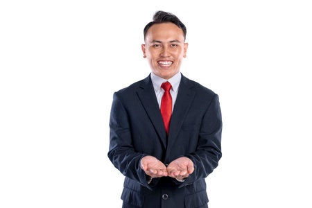Portrait of an Asian businessman standing with open palm hand isolated over a white background. Copy...
