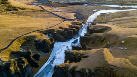 Aerial landscape view of Fjarrgljfur or Fjadrargljufur Canyon with Fjadrar river flow on Iceland. Taken by drone. Nature, travel, winter background, or wallpaperの写真素材