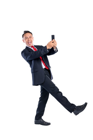 Portrait of an Asian businessman using his mobile phone isolated over a white background. Concept of Indonesian business and technologyの写真素材