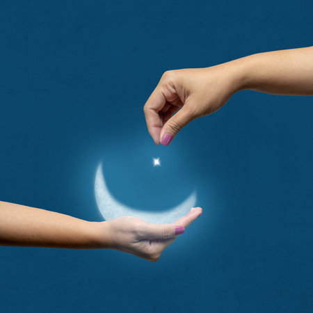 A human hand showing a crescent moon and star in the night scene background. Concept of Religion, Spiritual or Ramadanの写真素材