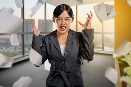 Businesswomen feel stressed with flying paperwork at the workplace. Concept of business problem and overworkedの写真素材