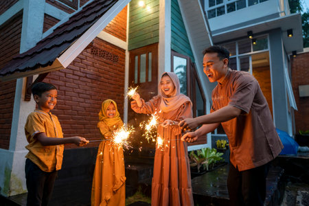 Asian Muslim family playing fireworks at hometown. Concept of Eid Al Fitr, Idul Fitri, and Ramadan Mubarak celebrationの写真素材