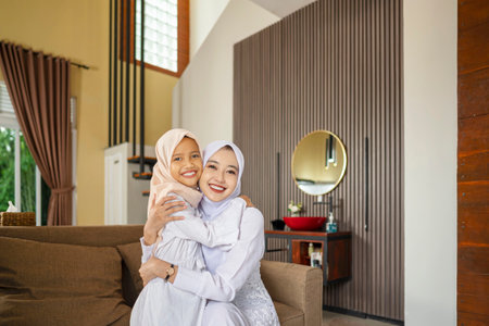 Portrait of the Indonesian Muslim mother with her daughter celebrating Eid Mubarak. Concept of Happy Lebaran, Eid Al Fitr, Idul Fitri, and Ramadan Mubarak celebrationの写真素材