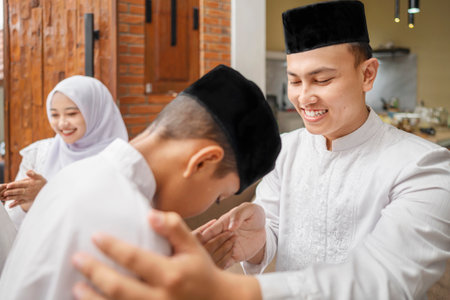 Portrait of the Indonesian Muslim boy asking forgiveness to his father while celebrating Eid Mubarak. Concept of Happy Lebaran, Eid Al Fitr, Idul Fitri, and Ramadan Mubarak celebrationの写真素材