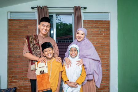 Portrait of the Indonesian Muslim family after Eid al-Fitr salat in front of the house. Concept of Happy Lebaran, Eid Al Fitr, Idul Fitri, and Ramadan Mubarak celebrationの写真素材