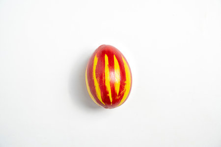 Top view of a colorful decorated easter egg isolated over a white background. Concept of celebrating the easter holidayの写真素材