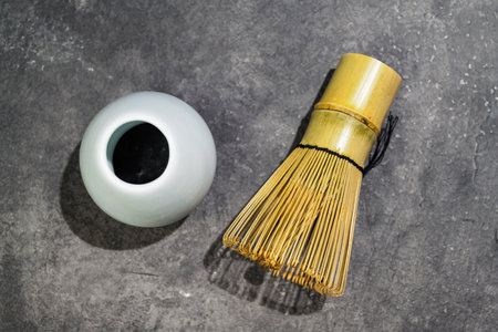 Traditional bamboo brush whisk or chasen on a black table. Accessories for making matcha green tea. Top viewの写真素材