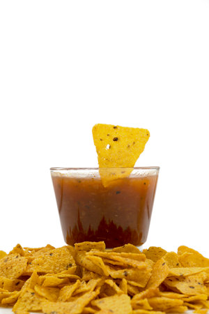 Nachos tortilla chips on salsa barbecue sauce in a glass bowl on a white background. Food and snacks conceptの写真素材