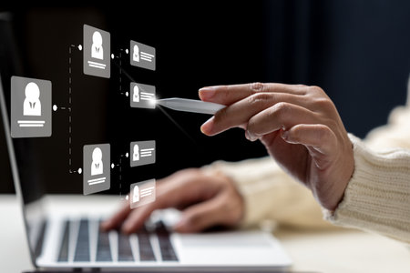 Businesswoman using laptop while touching the flowchart icon of a human representing potential candidates. Technology innovation on a virtual screen. Concept of human resources recruitment and hiringの写真素材