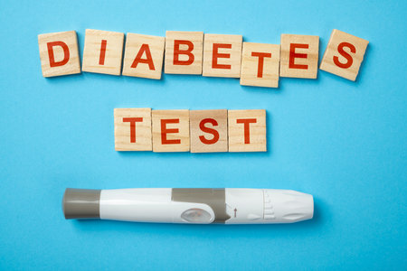 Lancet for checking blood sugar level with text of diabetes test on wooden cubes. Concept of diabetes or a healthy lifestyleの写真素材