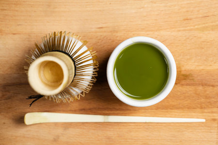 Matcha green tea with a traditional bamboo brush whisk and a spoon on a table. Accessories for making matcha green tea. Top viewの写真素材