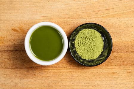 Closeup view of matcha green tea in the bowl and matcha green tea powder in the black bowl on the table. Top viewの写真素材