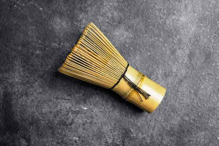 Traditional bamboo brush whisk or chasen on a black table. Accessories for making matcha green tea. Top viewの写真素材