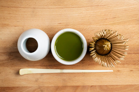 Matcha green tea with a traditional bamboo brush whisk and a spoon on a table. Accessories for making matcha green tea. Top viewの写真素材