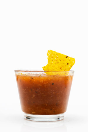 Nachos tortilla chips on salsa barbecue sauce in a glass bowl on a white background. Food and snacks conceptの写真素材