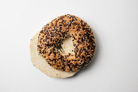Closeup view of slice of bagel bread with sesame seeds isolated over white background. Top viewの写真素材