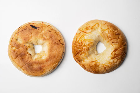 Closeup view of slice of bagel breads isolated over white background. Top and bottom part. Top view