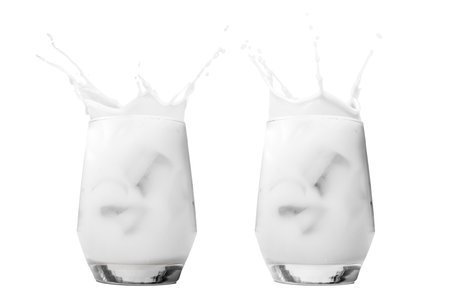 Two iced milk or cream in a glass with a splash isolated over a white backgroundの写真素材
