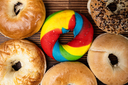 Closeup view of a collection of bagel breads with various kinds on a wooden board. Top viewの写真素材