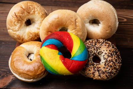 Closeup view of a collection of bagel breads with various kinds on a wooden board. Top viewの写真素材