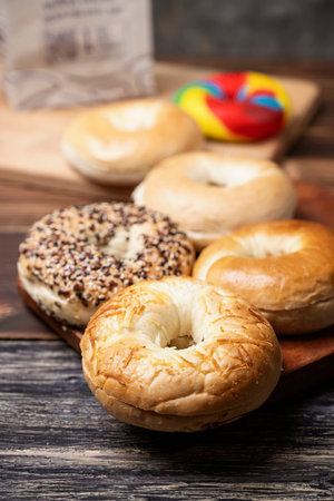 Closeup view of a collection of bagel breads with various kinds on a wooden boardの写真素材