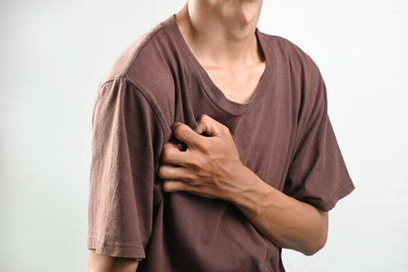 Portrait of man have heart attack or heart disease isolated over white background. Concept of healthcareの写真素材