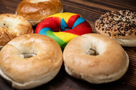 Closeup view of a collection of bagel breads with various kinds on a wooden boardの写真素材