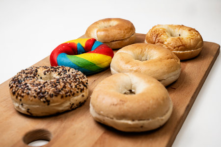 Closeup view of a collection of bagel breads with various kinds on a wooden board isolated over a white backgroundの写真素材