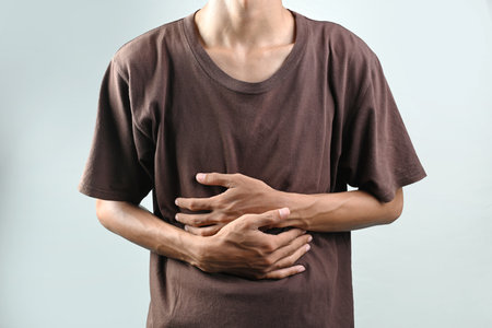 Portrait of man feeling stomach ache isolated over white background. Concept of healthcareの写真素材