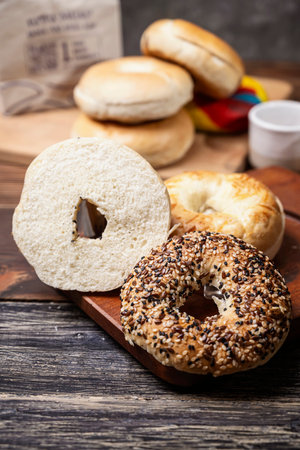 Closeup view of a variety of kinds of bagel breads with sliced bagel bread on a wooden boardの写真素材