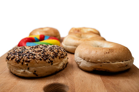 Closeup view of a collection of bagel breads with various kinds on a wooden board isolated over a white backgroundの写真素材