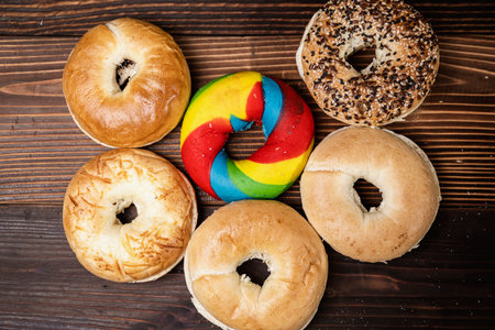 Closeup view of a collection of bagel breads with various kinds on a wooden board. Top viewの写真素材