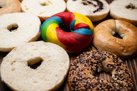 Closeup view of a variety of kinds of bagel breads with sliced bagel bread on a wooden boardの写真素材