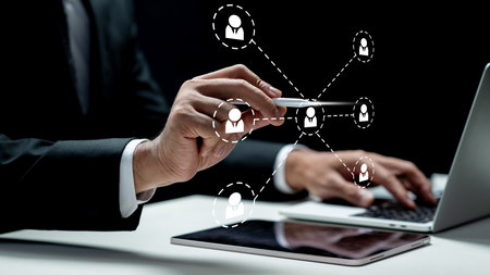 Businessman using a laptop while touching the connected people icon on the tablet screen. Technology...