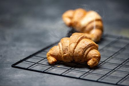 Croissants on a cooling tray with a black backgroundの写真素材
