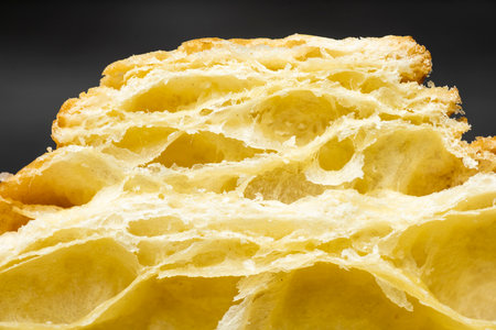 Closeup view slice of freshly baked croissant with a black backgroundの写真素材