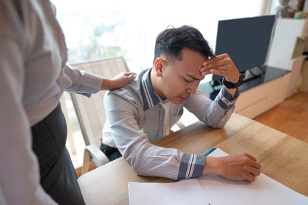 Indonesian southeast asian businessman gets advice from his boss for being late or for the stress of...