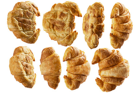 Closeup view of a set collection of freshly baked croissants in various kinds of angles isolated over a white backgroundの写真素材