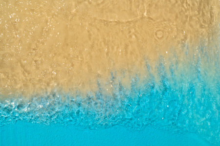 Aerial view of clean and transparent blue ocean waves on a beautiful sandy beach. Natural background. Summer conceptの写真素材